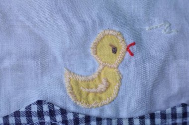 embroidered yellow chicken patch on gray fabric on clothes