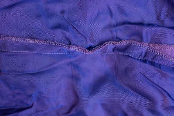 lilac texture of fabric from a piece of synthetic with a seam