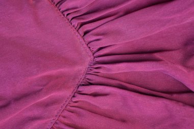 red texture of crumpled fabric with a seam on clothes