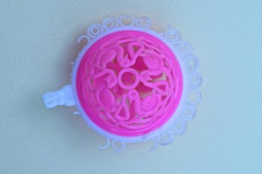 part one round pink white plastic rattle toy lies on a gray table