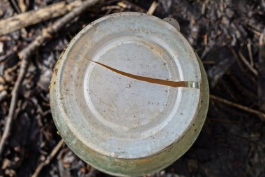 one old broken plastic white cap with a crack on a glass jar outdoors