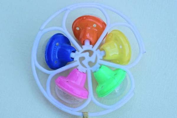 one round plastic colored small dirty toy rattle lies on a gray table