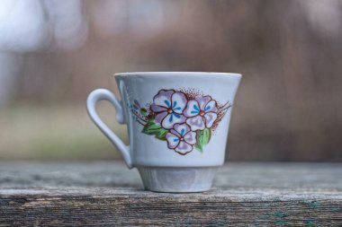 Bir küçük beyaz kahve fincanı gri bir masanın üzerinde duruyor.