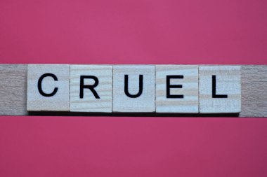 Gri ahşap harflerden zalim sözcüğünü yaz. Kırmızı bir masanın üzerinde siyah yazı tipi olan küçük harfler.