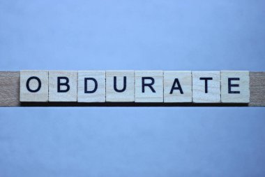 Gri arkaplanda siyah yazı tipi olan kahverengi ahşap harflerden 