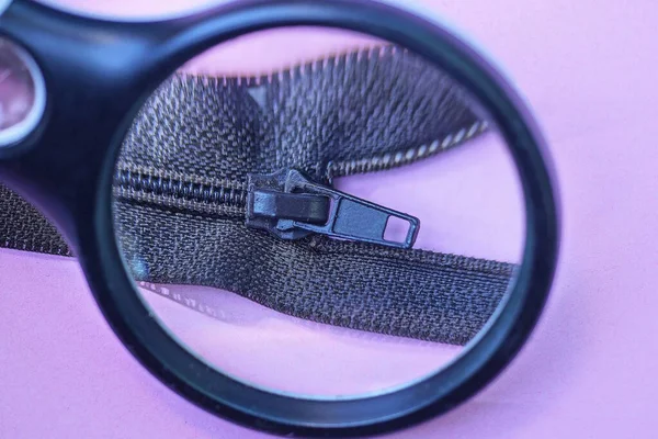 Una Lente Ingrandimento Ingrandisce Dettaglio Abbigliamento Una Zip Plastica Nera — Foto Stock