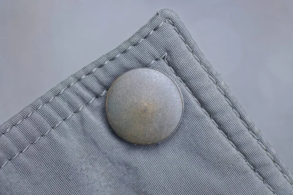 Jeden Brązowy Zielony Metalowy Przycisk Nit Szarym Materiale Ubraniu — Zdjęcie stockowe
