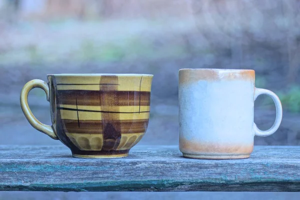 Две Коричневые Керамические Большие Чашки Стоят Сером Столе Улице — стоковое фото