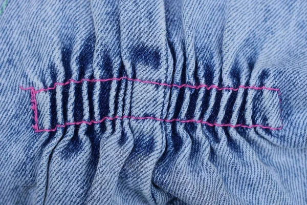 マッシュとシャビーのデニムのブルーグレーの生地の質感が赤い糸の縫い代でパンツに — ストック写真