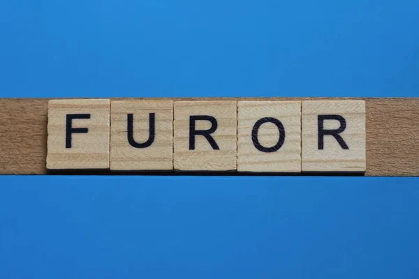 由木灰色字母构成的单词Furor位于蓝色的背景上 — 图库照片