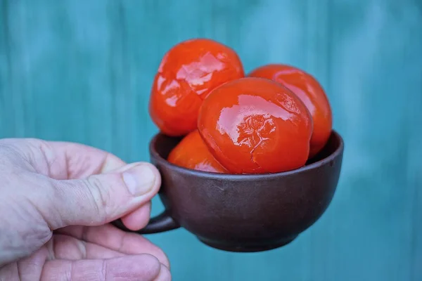 Ręka Trzyma Brązowy Kubek Czerwonymi Pomidorami Puszce Zielonym Tle — Zdjęcie stockowe