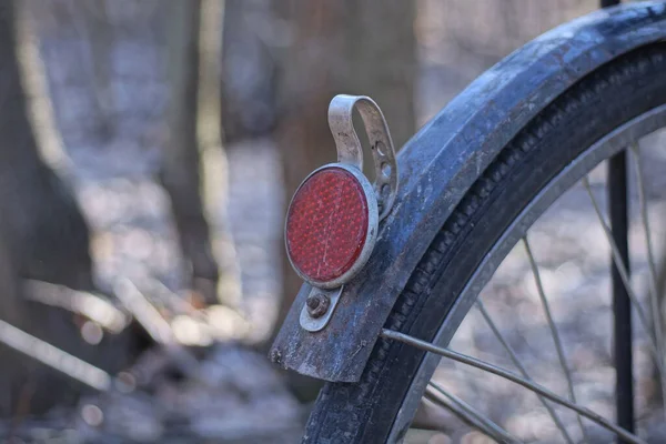 街上一辆黑色自行车轮子上方蓝色金属挡泥板上的一个红色圆形塑料反射镜 — 图库照片