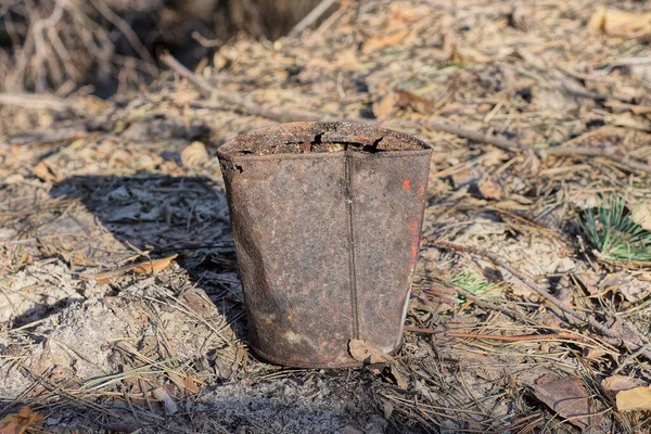 大きな茶色の錆びた鉄の缶が通りの灰色の乾燥した葉と土の上に立って — ストック写真