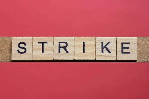 赤いテーブルの上に黒いフォントで灰色の木製の小さな文字から単語ストライキをテキスト — ストック写真