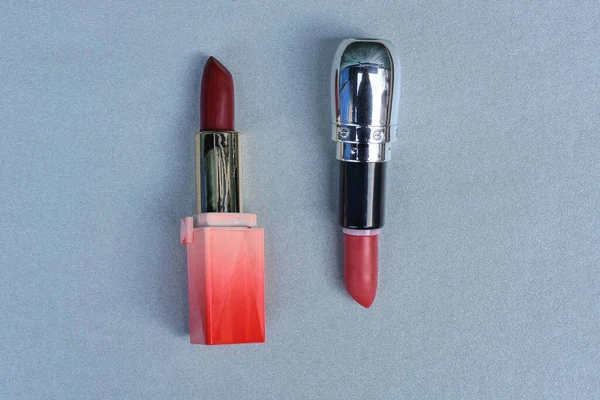 Dua Tabung Plastik Lipstik Merah Terletak Meja Abu Abu — Stok Foto