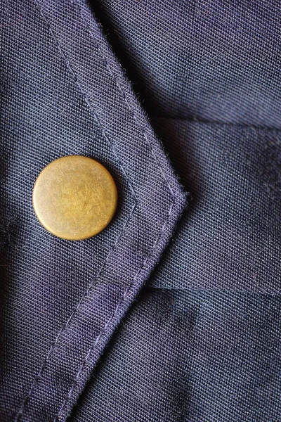 stock image one brown metal rivet button on blue fabric pocket on clothes