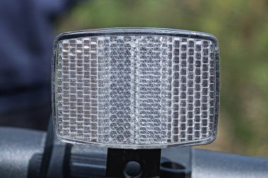 Siyah bisiklet gidonunda beyaz dikdörtgen plastik yansıtıcı.