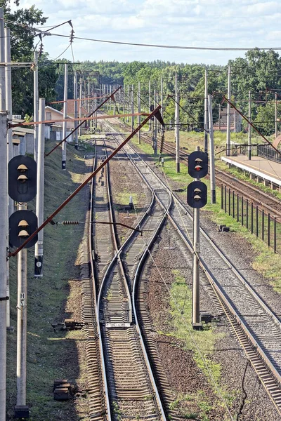 铁路的一部分 有铁轨 卧铺和杆子 在天空和绿色植被的背景下 有半挂号 — 图库照片