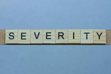 Gri bir masada siyah yazı tipi olan kahverengi ahşap harflerden 