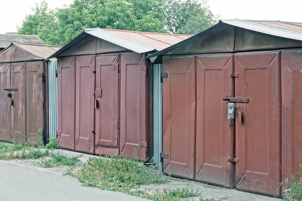 Rząd Trzech Brązowych Zamkniętych Starych Garaży Metalowych Ulicy Asfalcie Zielonej — Zdjęcie stockowe