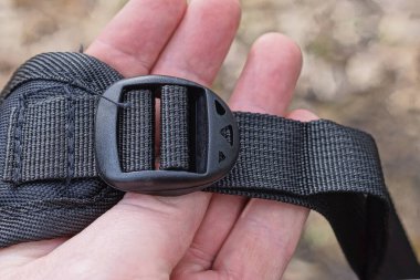 Sırt çantasındaki kayış takımında kapalı küçük siyah plastik bir karabina var.