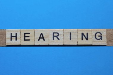 Kelime duyma ahşap gri harflerden yapılmıştır mavi bir arka planda yatar