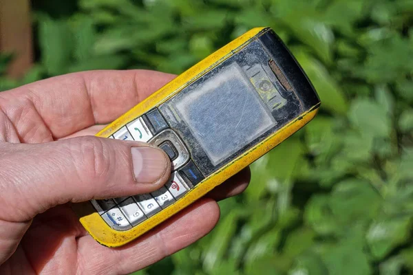 Рука Тримає Старий Жовтий Чорний Мобільний Телефон Вулиці Фоні Зеленої — стокове фото