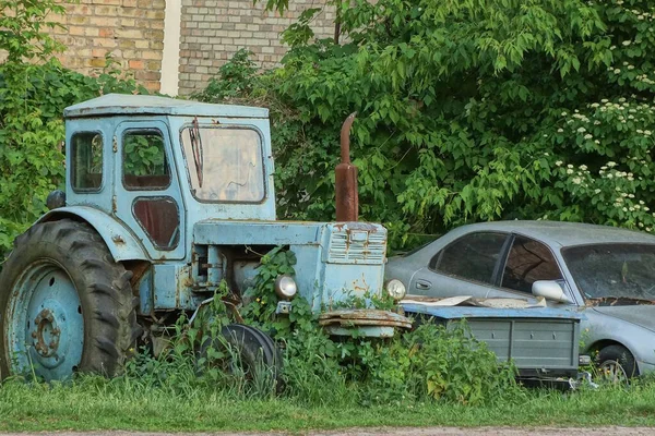Jeden Stary Niebieski Ciągnik Wiejski Stoi Ulicy Porośnięty Zieloną Trawą — Zdjęcie stockowe
