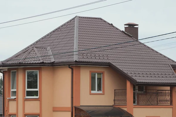 一间私人住宅的棕色阁楼 有一个敞开的铁制阳台 在街道上的屋顶上 与天空相对照 — 图库照片