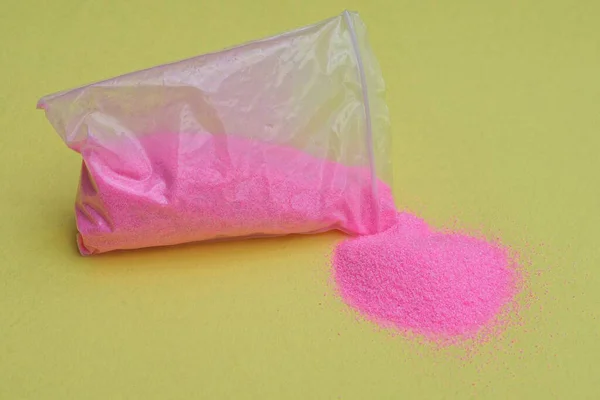 Одна Маленька Пластикова Сумка Рожевим Піском Жовтому Столі — стокове фото