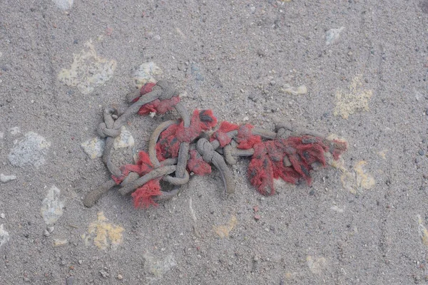 Kawałki Starych Czerwonych Szarych Lin Węzłami Leżą Piasku Ulicy — Zdjęcie stockowe