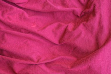 Eski kıyafetlerdeki buruşuk kumaş parçasının kırmızı dokusu.