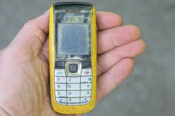 Рука Тримає Один Старий Жовтий Чорний Мобільний Телефон Вулиці Сірому — стокове фото