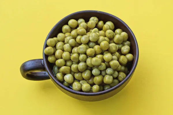 Food Green Canned Peas Brown Cup Stands Yellow Table — Stock Photo, Image