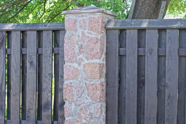 在街上用木板和石头筑成的篱笆的灰褐色墙壁上的部分 — 图库照片