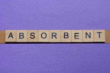 Tahta gri harflerden yapılmış kelime emici leylak arka planda yatıyor.