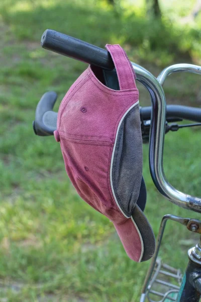Красный Черный Колпак Ткани Висит Руле Старого Велосипеда Фоне Зеленой — стоковое фото