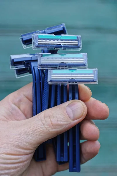 Yeşil Arka Planda Bir Sürü Mavi Plastik Tıraş Bıçağı Var — Stok fotoğraf