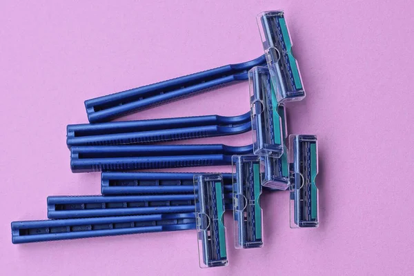 Conjunto Navajas Afeitar Plástico Azul Encuentran Una Mesa Rosa — Foto de Stock
