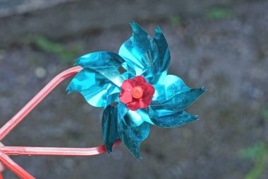 Bir küçük mavi plastik oyuncak yel değirmeni Gri arka planda sokakta