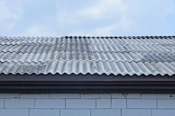 通りの白いレンガ造りの民家にある灰色のスレート屋根が青い空に対して — ストック写真