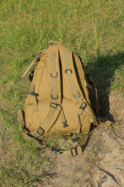 One Brown Army Backpack Stands Gray Ground Green Grass Street — Stock Photo, Image