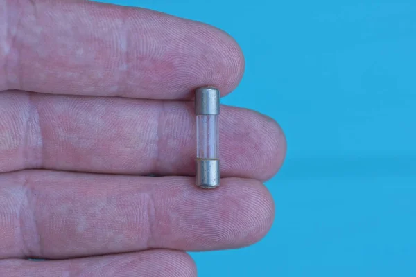 Eine Kleine Elektrische Graue Glasmetallsicherung Liegt Auf Den Fingern Auf — Stockfoto