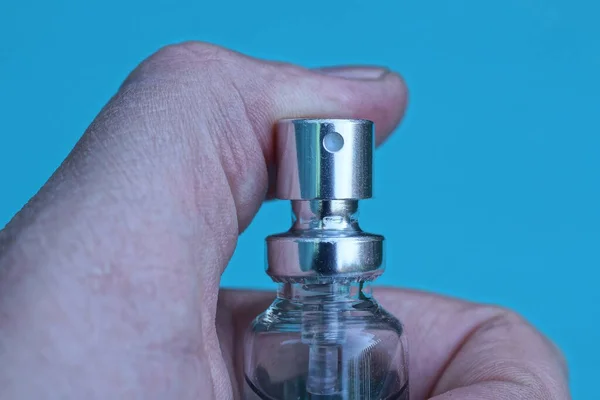 Eine Graue Flasche Den Fingern Der Hand Auf Blauem Hintergrund — Stockfoto
