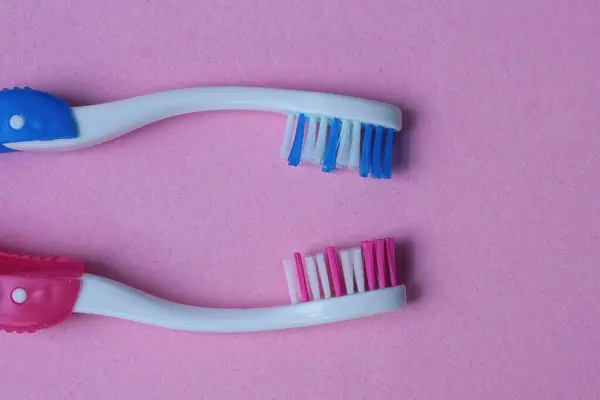 Sada Dvou Barevných Plastových Zubních Kartáčků Leží Růžovém Stole — Stock fotografie
