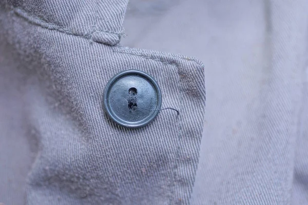Одна Большая Черная Пластиковая Кнопка Серой Ткани Одежде — стоковое фото