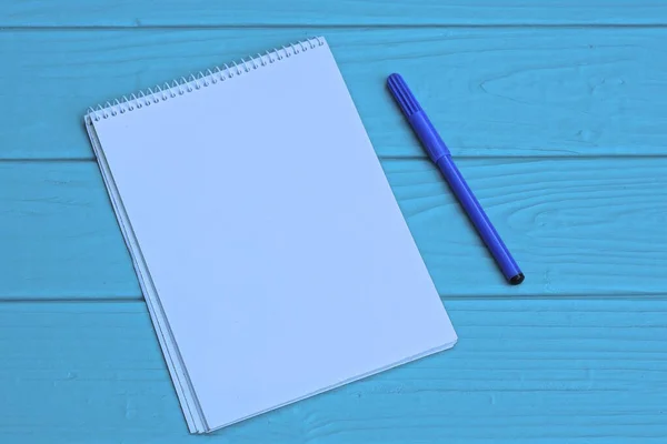 Jeden Otevřený Bílý Zápisník Plastovým Perem Leží Modrém Dřevěném Stole — Stock fotografie