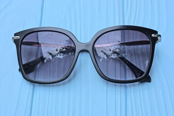 Svart Plast Solglasögon Med Lila Linser Ligger Ett Blått Träbord — Stockfoto