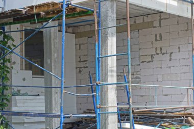 Demir iskelenin bir parçası. Caddedeki beyaz duvarın yanında tahta tahtalar var.