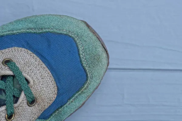 Parte Tênis Feito Camurça Verde Tecido Azul Sobre Uma Mesa — Fotografia de Stock